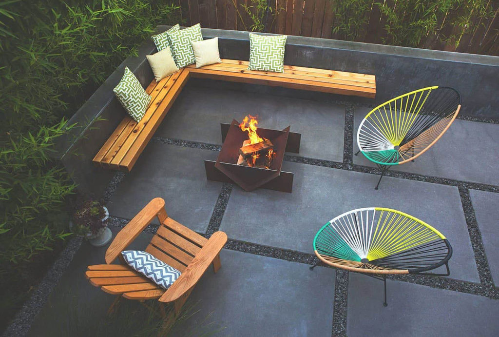 Modern backyard with wooden bench and metal outdoor fire pit