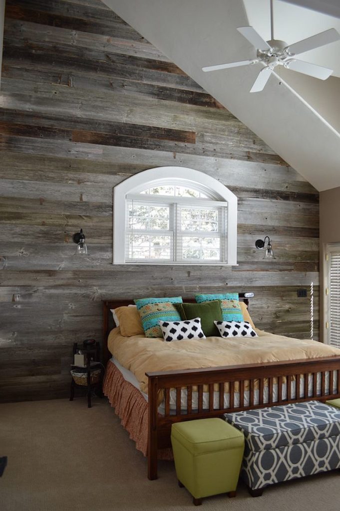 Grey washed reclaimed wood is used in this loft room for a traditional barn charm. The window sits just above the double bed.