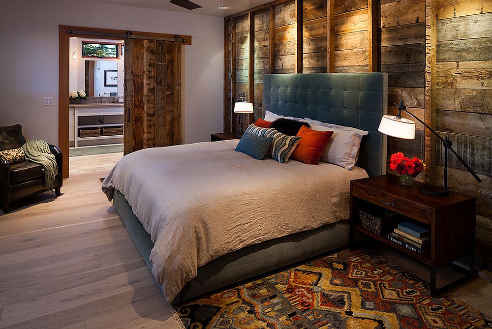 Reused wood as bedroom wall cladding with exposed vertical support frames to divide the wall and downlight for effect