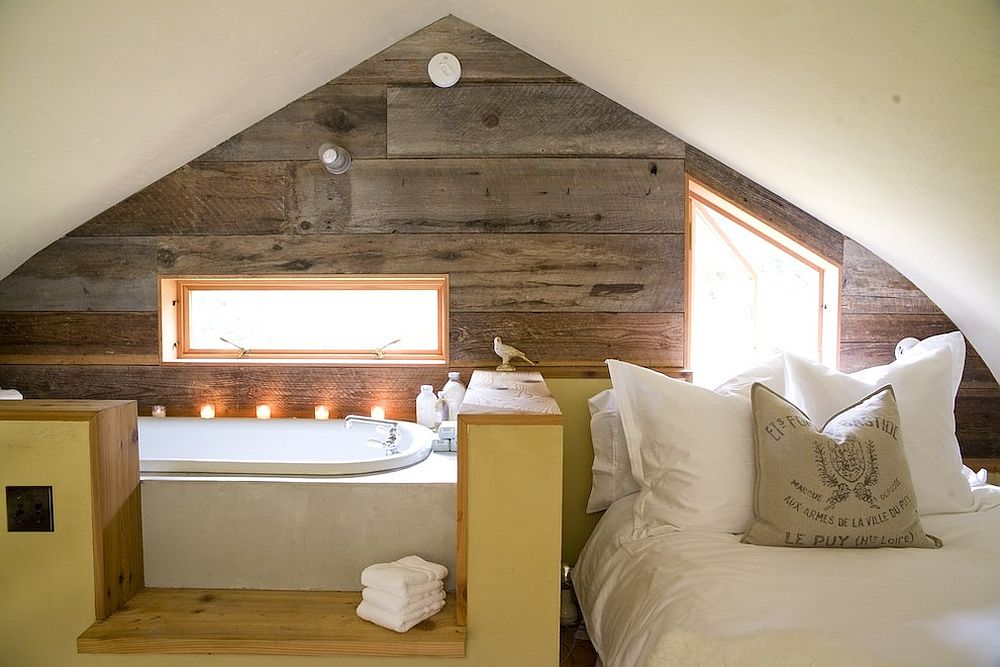 Small loft room with savvy use of space with a wooden effect wall that unifies both the open plan bedroom and bathroom