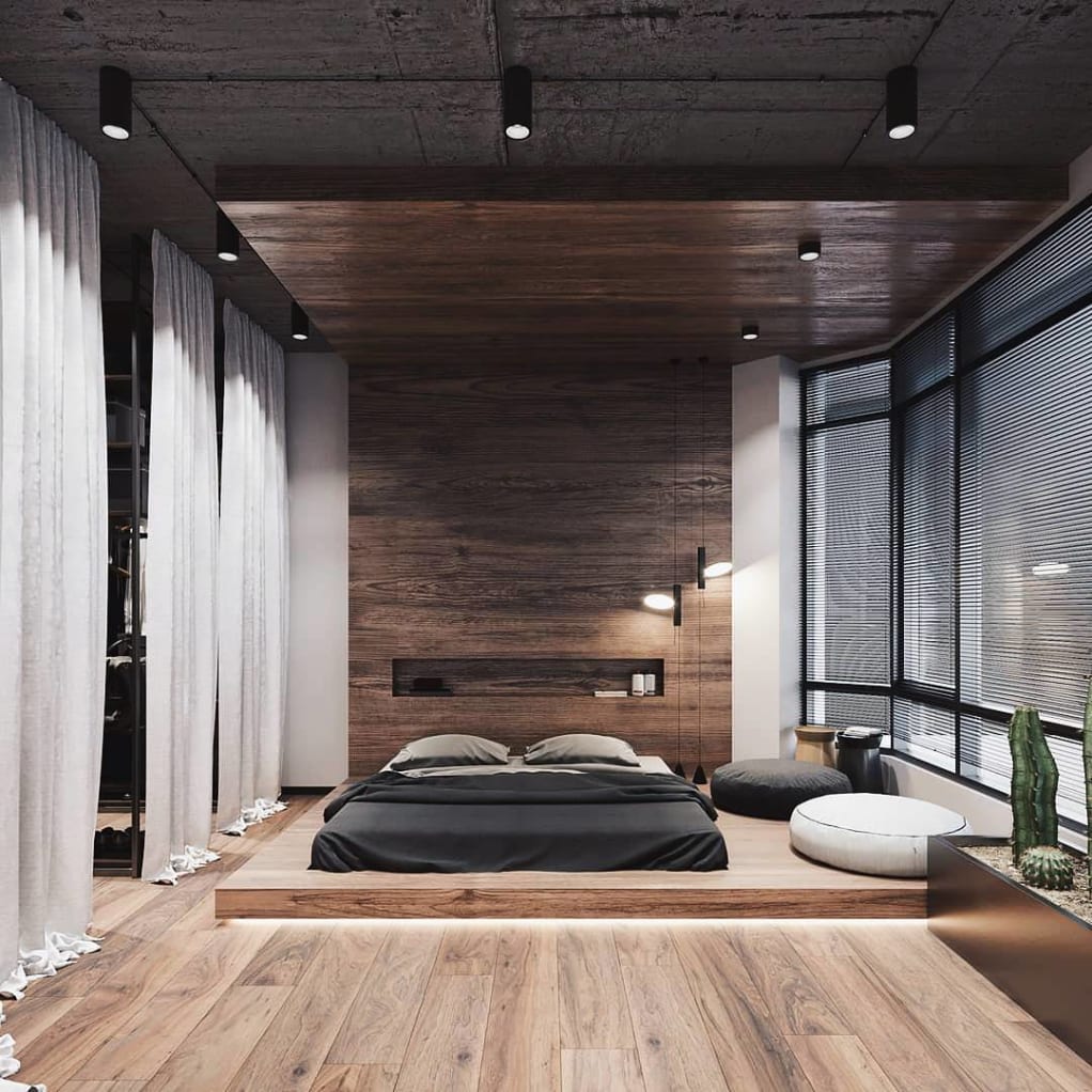 City Pad with wooden feature wall in bedroom with low raised bed on raised platform 