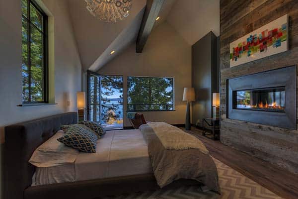 Standing out from the rest, the wooden feature wall with built-in fire place sits opposite the bed.