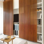 This wooden decorative wall paneling also works to hide the shelves and media unit