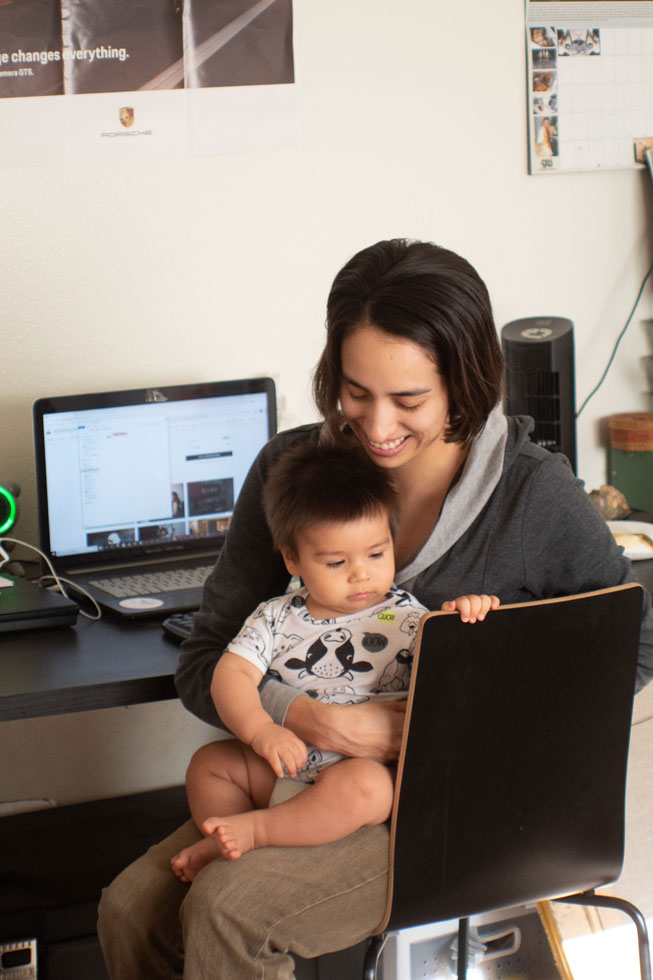Parenting with baby on lap at work desk at home